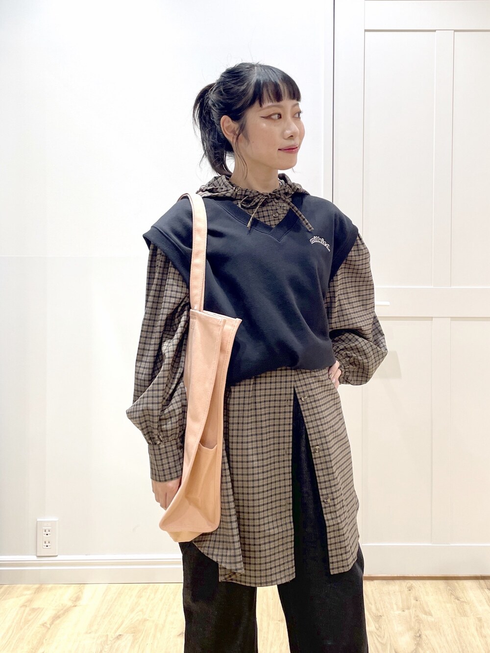 ブラック系のベスト、ブラウン系のシャツ/ブラウス、ブラック系のデニムパンツを着用したレディースの秋コーディネートの4枚目の写真