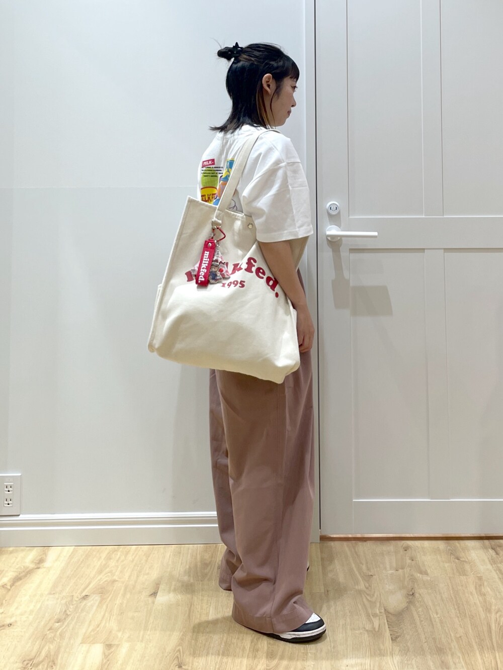 ホワイト系のTシャツ/カットソー、ホワイト系のスニーカー、ホワイト系のトートバッグを着用したレディースの夏コーディネートの3枚目の写真