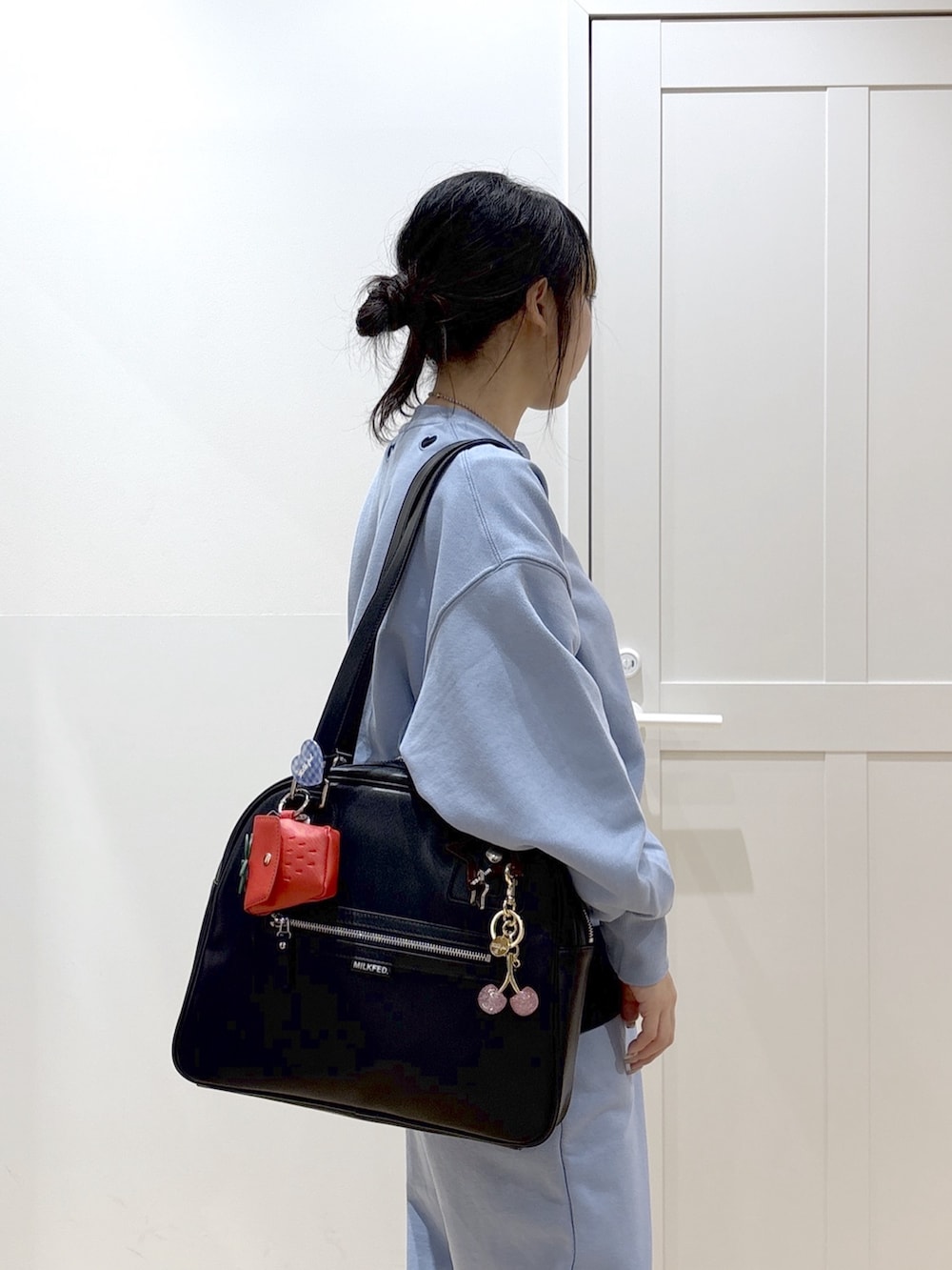 ブラック系のブーツ、ブルー系のスウェットパンツ、グリーン系のボストンバッグを着用したレディースの春コーディネートの6枚目の写真