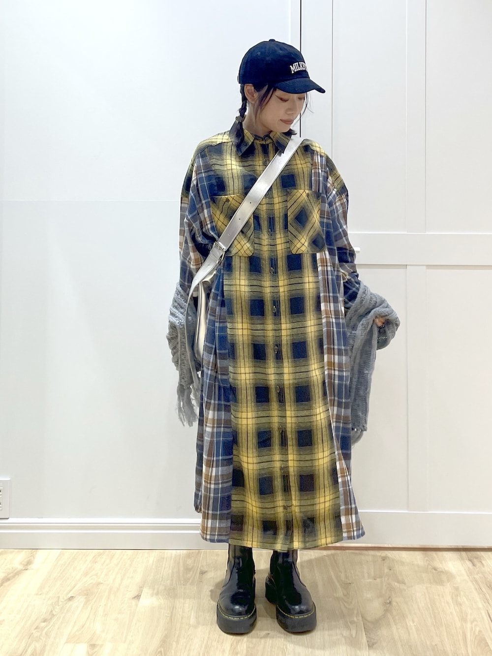 イエロー系のワンピース、ブラック系のブーツ、シルバー系のショルダーバッグを着用したレディースの秋コーディネートの6枚目の写真