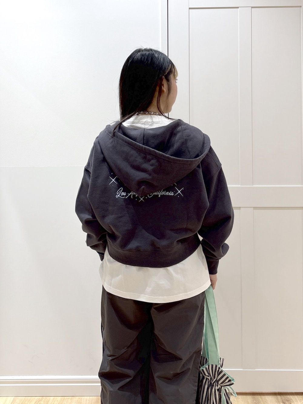 グレー系のその他パンツ、グレー系のパーカー、ホワイト系のTシャツ/カットソーを着用したレディースの冬コーディネートの6枚目の写真