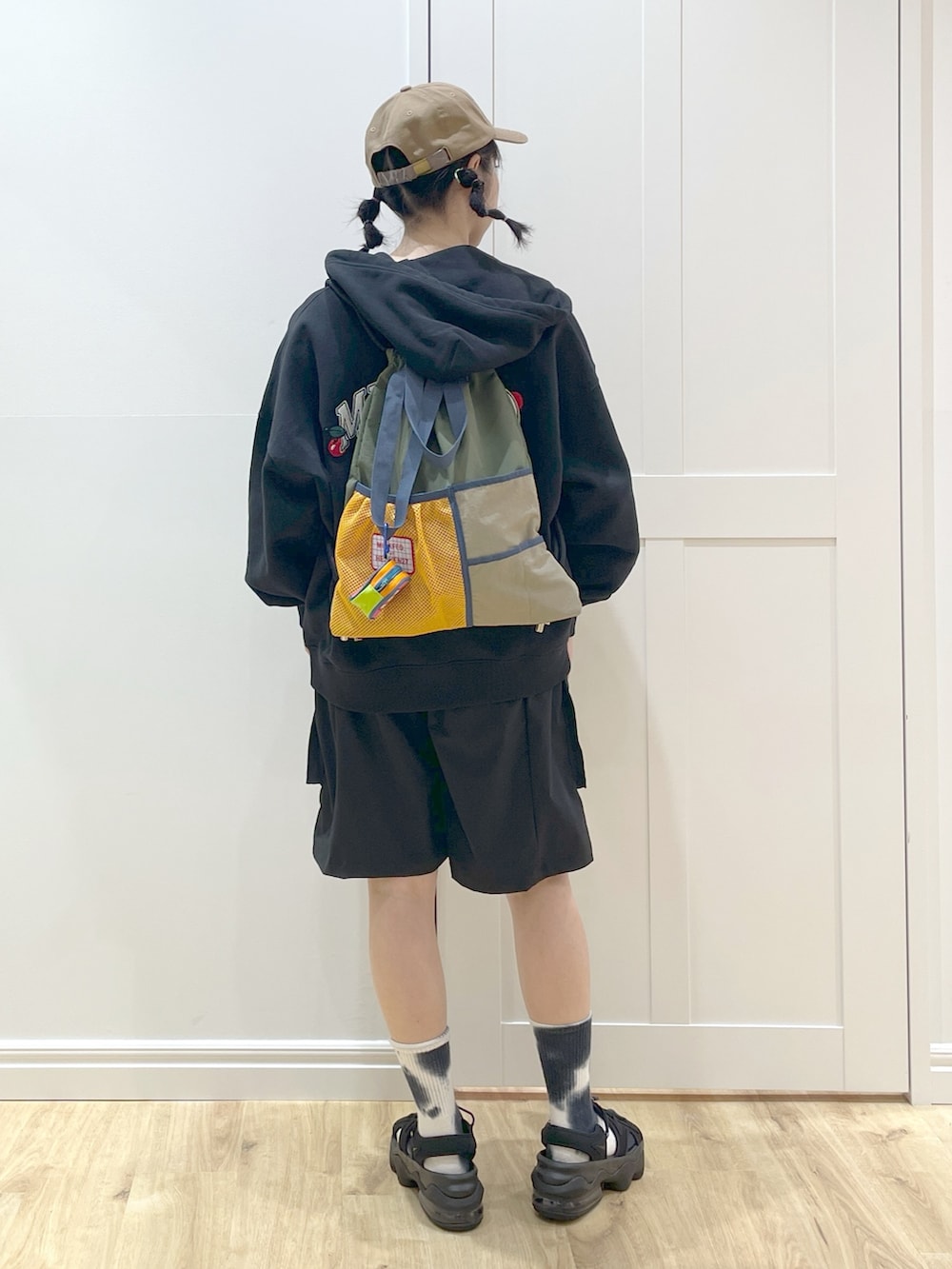 グリーン系のバックパック/リュック、ブラック系のパーカー、ホワイト系のタンクトップを着用したレディースの春コーディネートの3枚目の写真