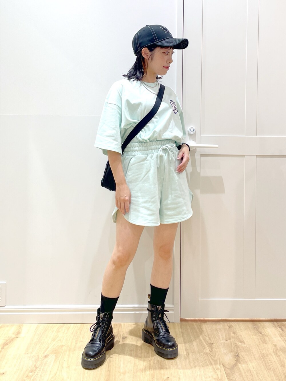 グリーン系のスウェットパンツ、グリーン系のTシャツ/カットソー、ブラック系のショルダーバッグを着用したレディースの夏コーディネートの2枚目の写真