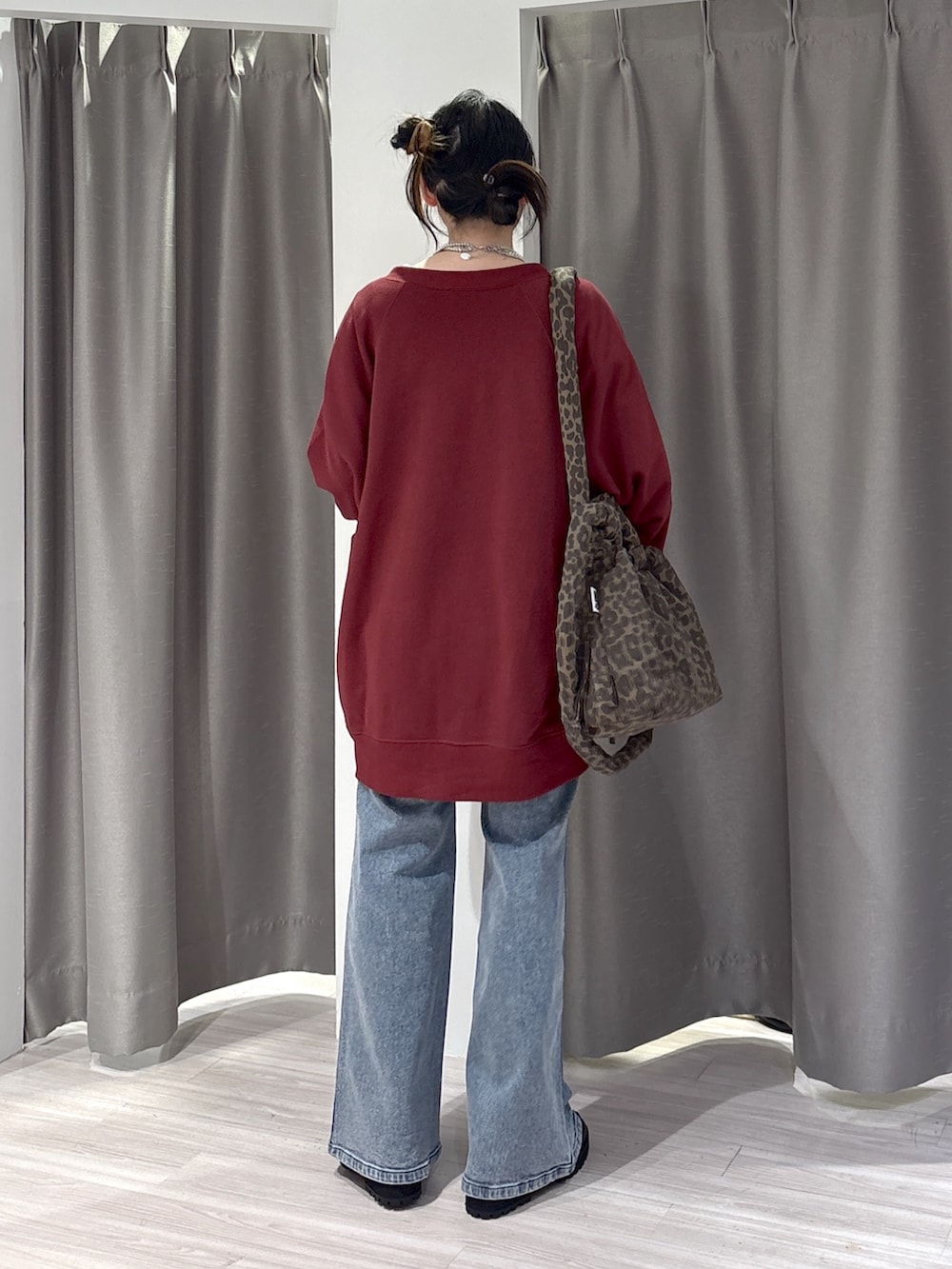 レッド系のスウェット、ホワイト系のTシャツ/カットソー、ブルー系のデニムパンツを着用したレディースの秋コーディネートの2枚目の写真