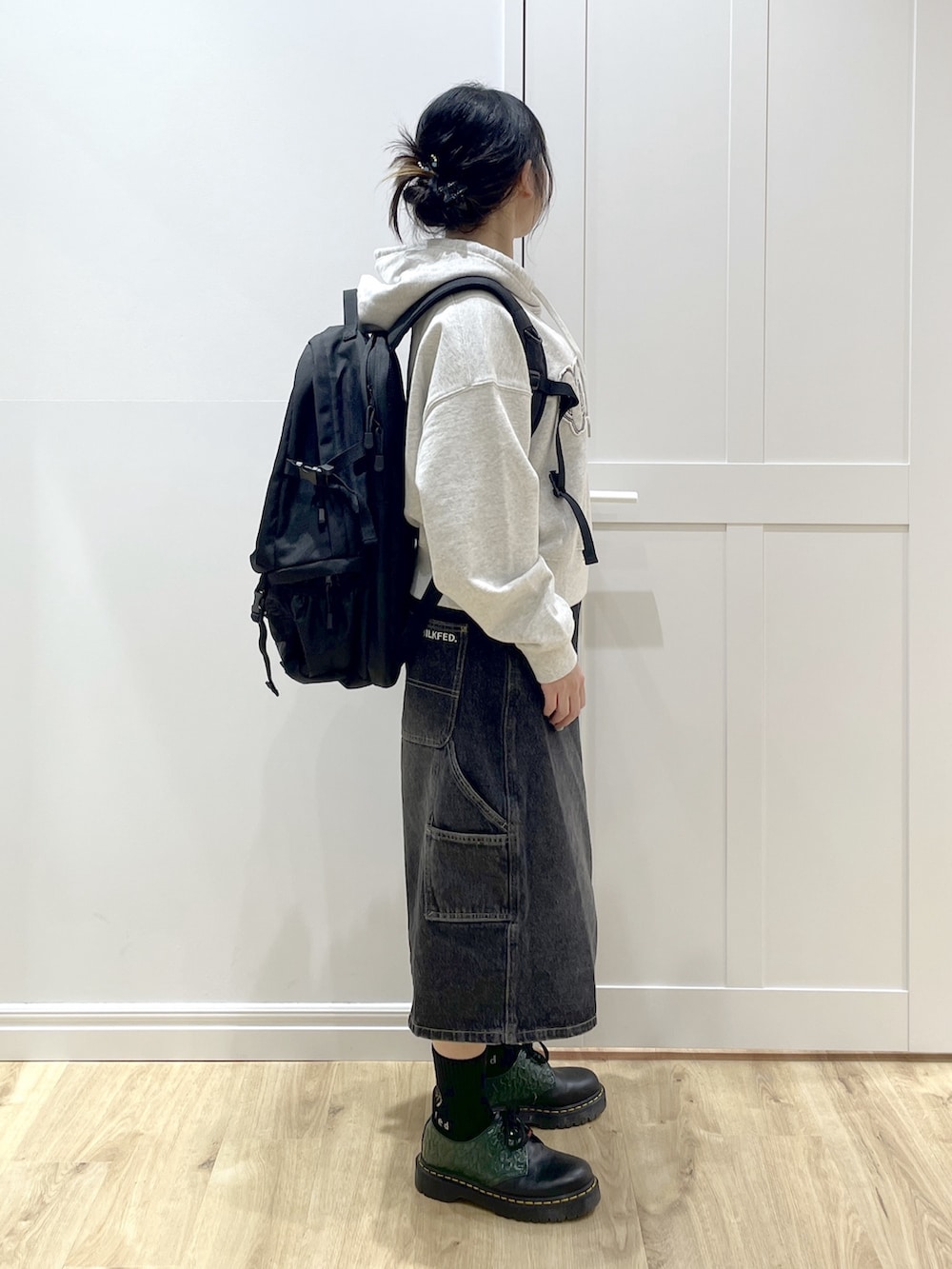 ブラック系のデニムパンツ、ベージュ系のパーカー、レッド系のバックパック/リュックを着用したレディースの冬コーディネートの4枚目の写真