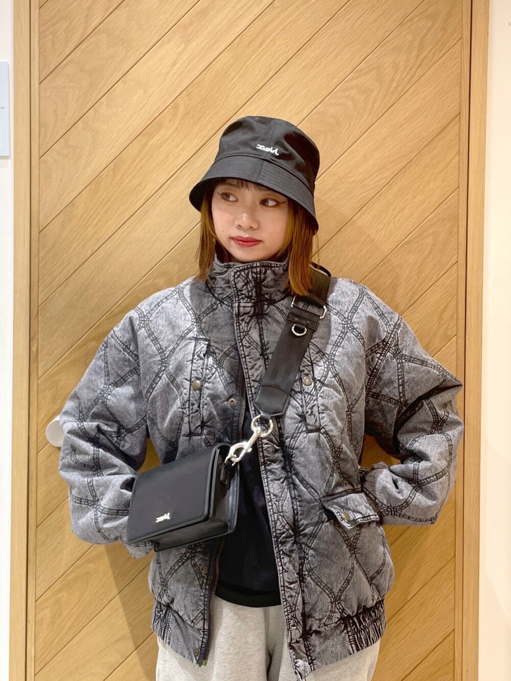グレー系のスウェットパンツ、ホワイト系のスニーカー、ブラック系のその他アウターを着用したレディースの冬コーディネートの3枚目の写真