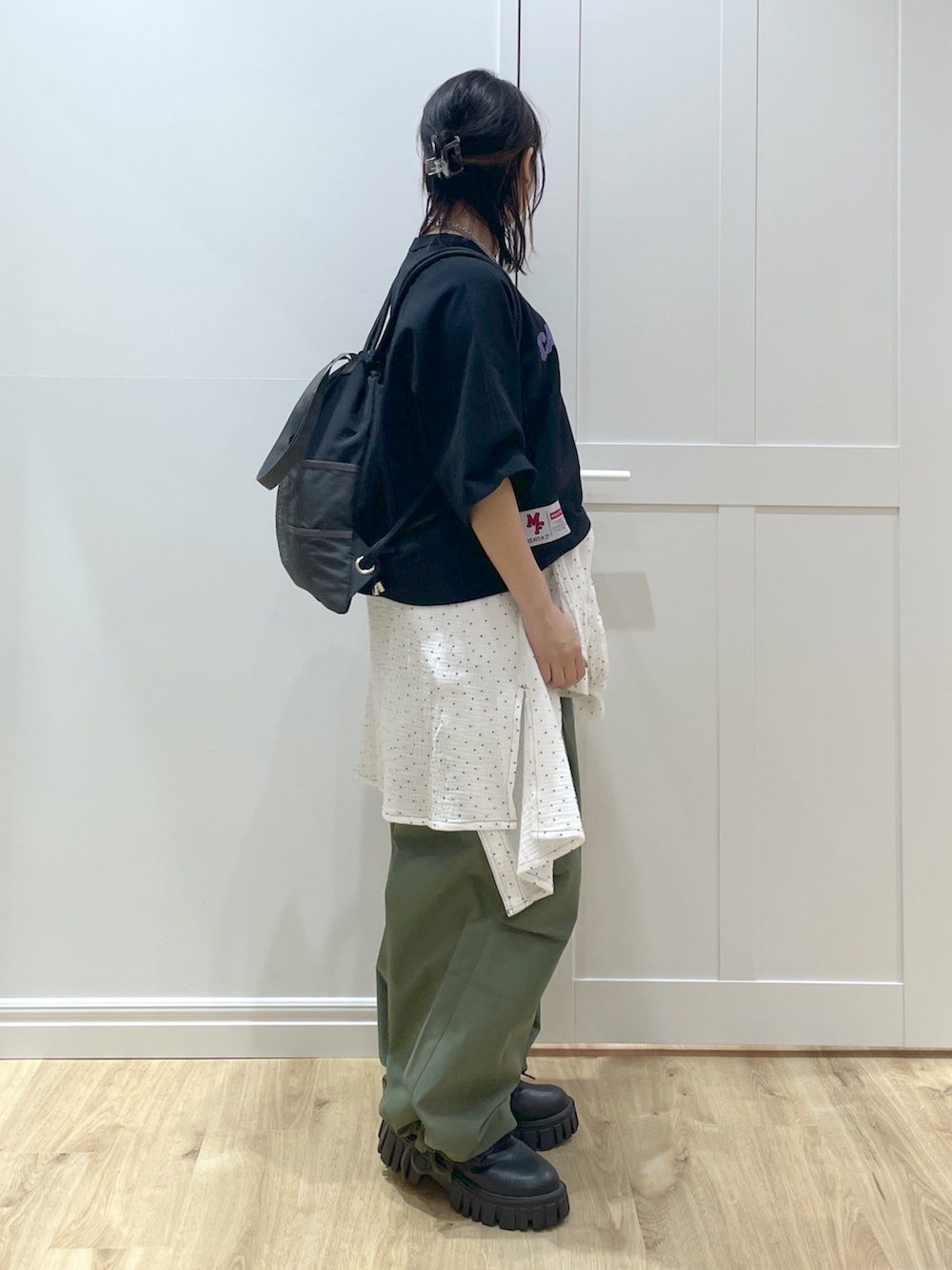 グリーン系のその他パンツ、ホワイト系のシャツ/ブラウス、ブラック系のTシャツ/カットソーを着用したレディースの春コーディネートの2枚目の写真