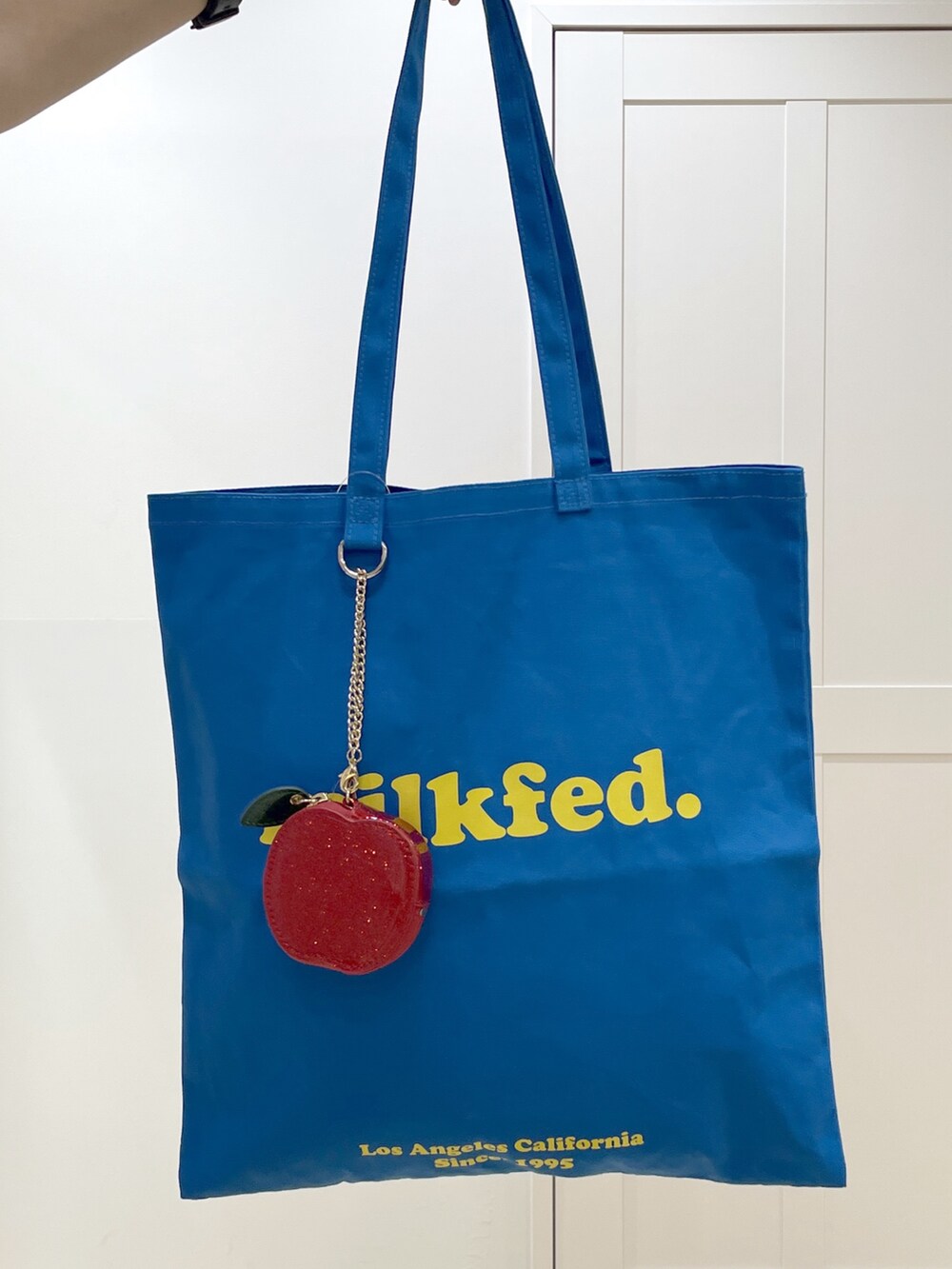 ブルー系のトートバッグ、ホワイト系のTシャツ/カットソー、ブラック系のパーカーを着用したレディースの冬コーディネートの6枚目の写真
