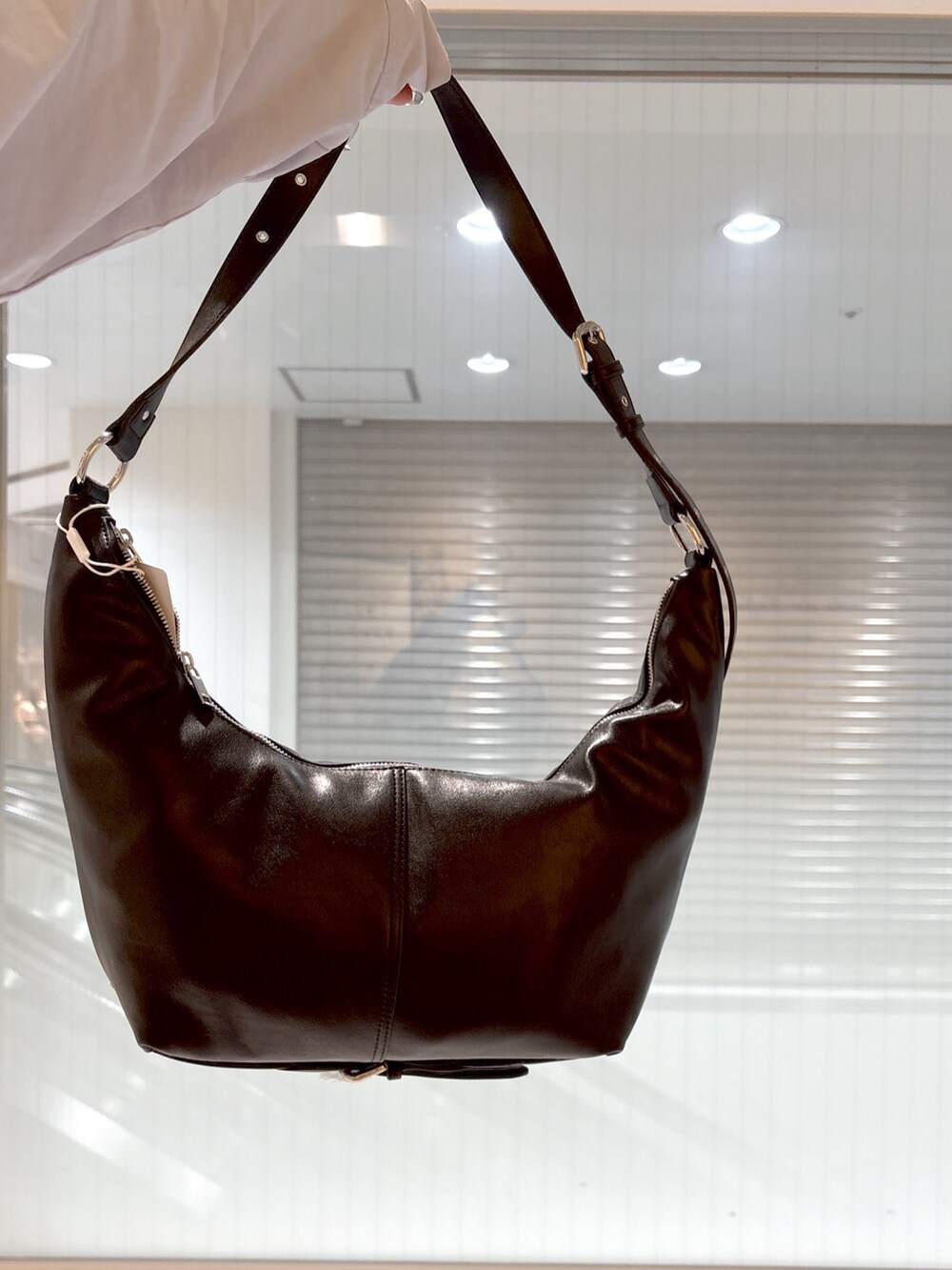 ブラック系のブーツ、ブルー系のシャツ/ブラウス、ベージュ系のテーラードジャケットを着用したレディースの春コーディネートの8枚目の写真