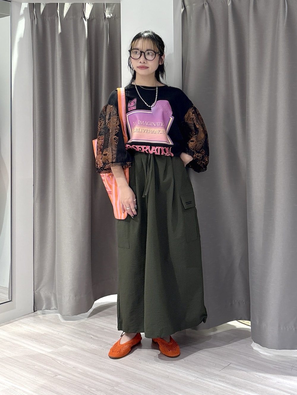 ブラック系のTシャツ/カットソー、グリーン系のスカート、ブラック系のパンプスを着用したレディースの夏コーディネートの2枚目の写真