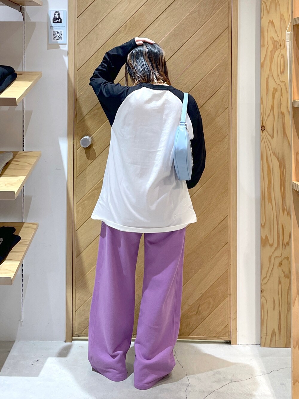 ブルー系のハンドバッグ、パープル系のスウェットパンツ、ブラック系のTシャツ/カットソーを着用したレディースの冬コーディネートの3枚目の写真