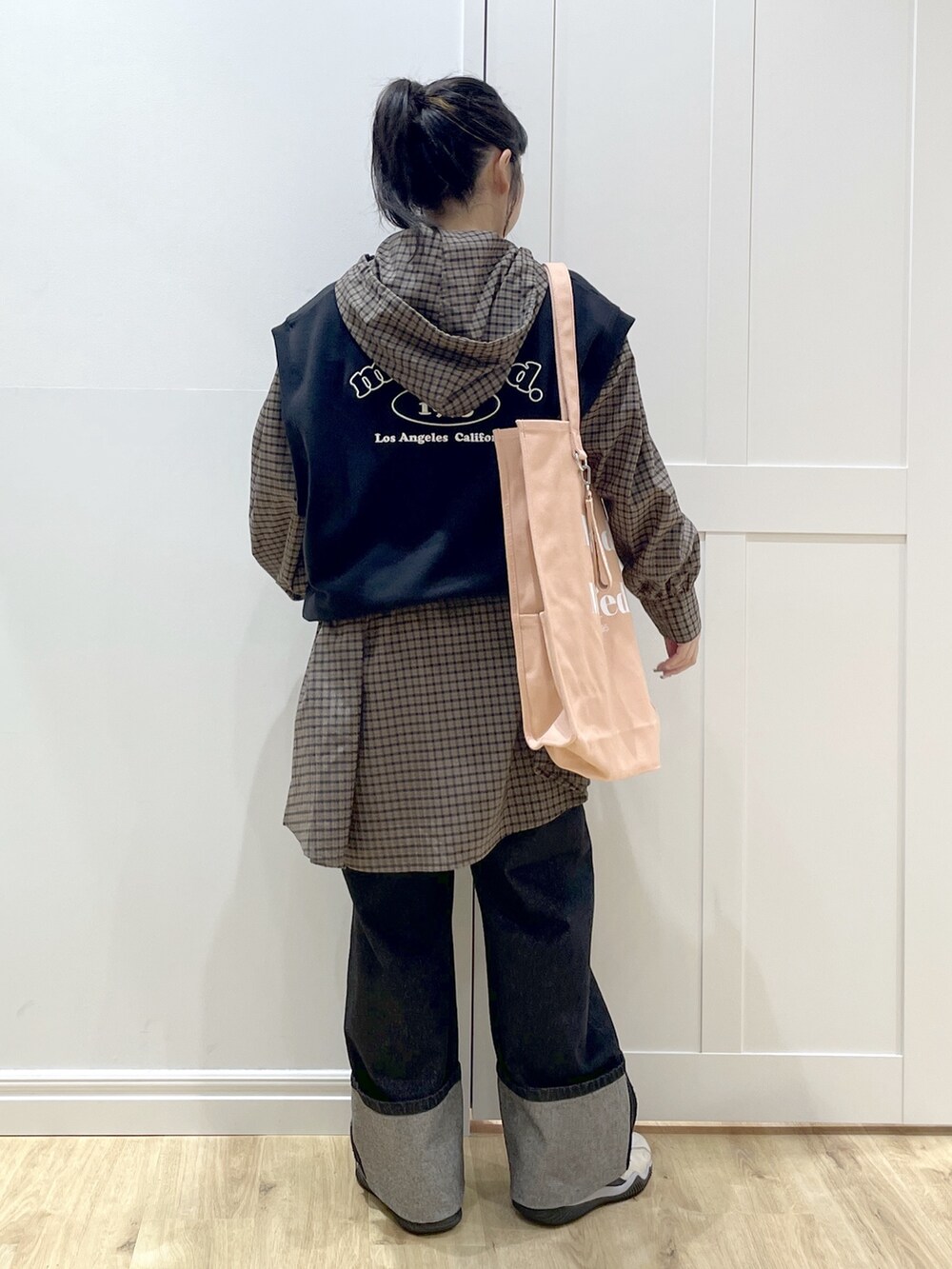 ブラック系のベスト、ブラウン系のシャツ/ブラウス、ブラック系のデニムパンツを着用したレディースの秋コーディネートの2枚目の写真