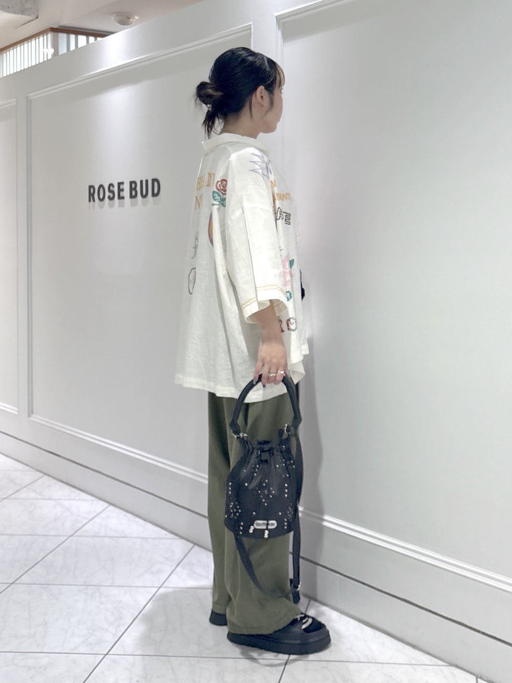 グリーン系のデニムパンツ、レッド系のタンクトップ、ブラック系のサンダルを着用したレディースの夏コーディネートの2枚目の写真
