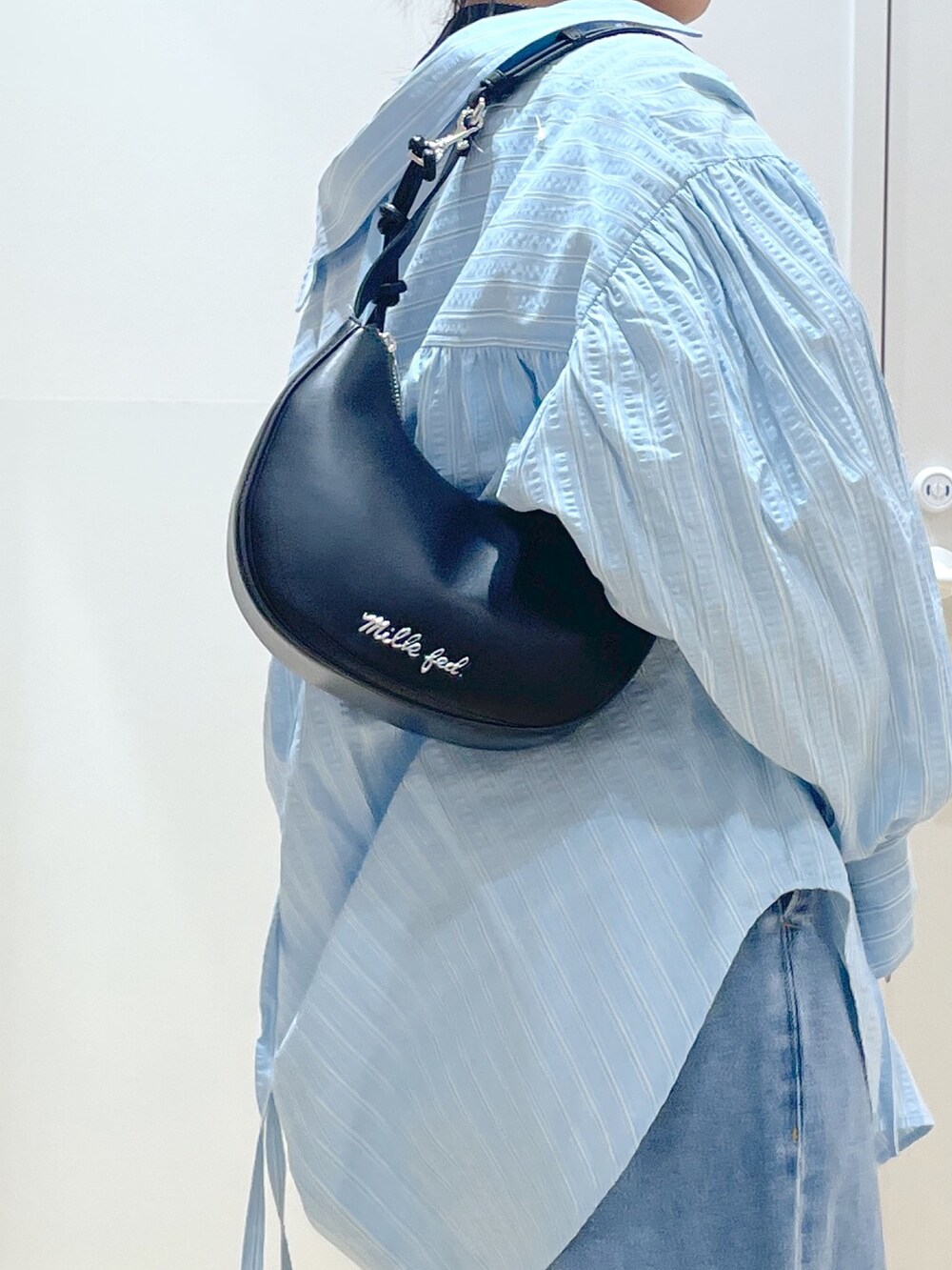 ブルー系のシャツ/ブラウス、ブラック系のTシャツ/カットソー、ブルー系のデニムパンツを着用したレディースの春コーディネートの2枚目の写真