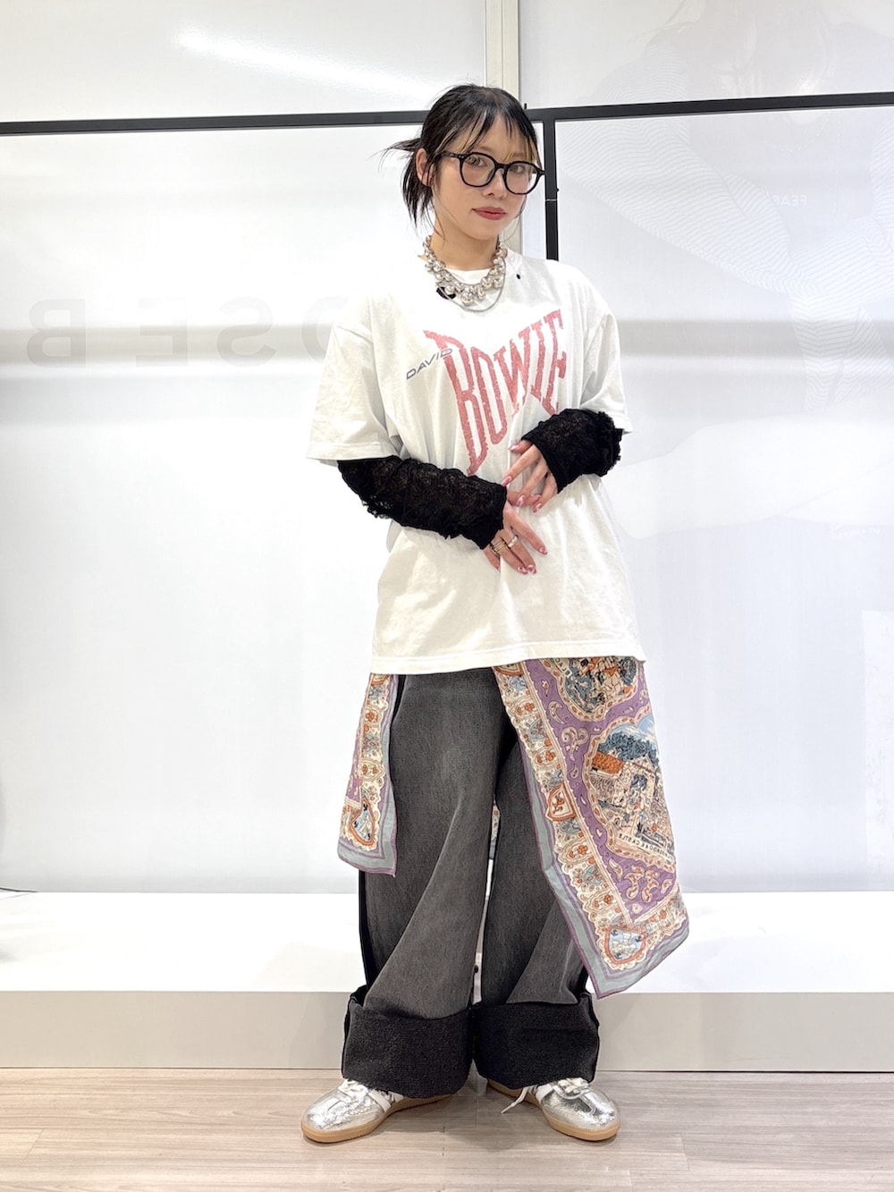 ブラック系のデニムパンツ、シルバー系のスニーカー、ホワイト系のTシャツ/カットソーを着用したレディースの春コーディネートの3枚目の写真