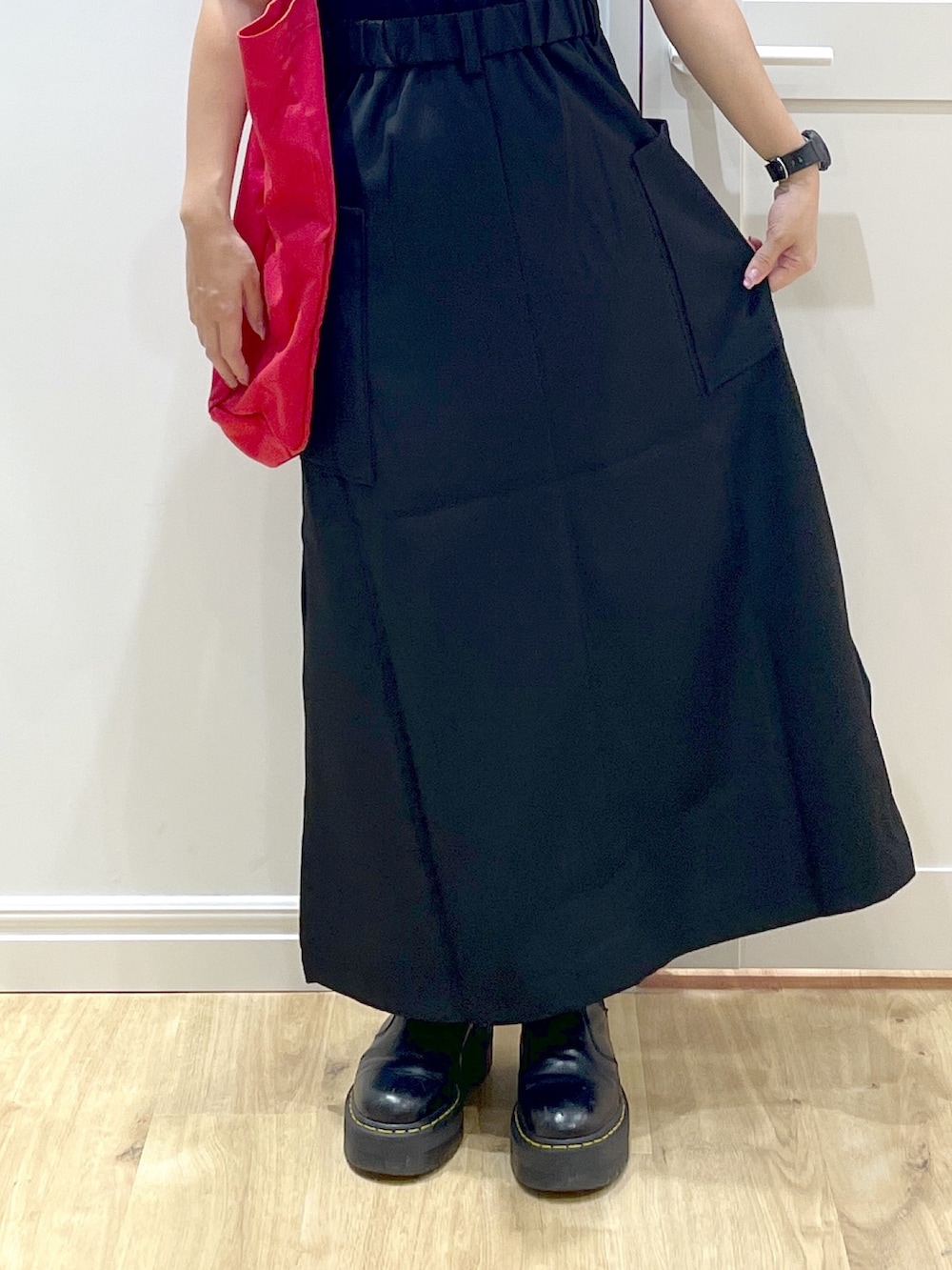 レッド系のトートバッグ、ブラック系のTシャツ/カットソー、ブラック系のスカートを着用したレディースの夏コーディネートの5枚目の写真