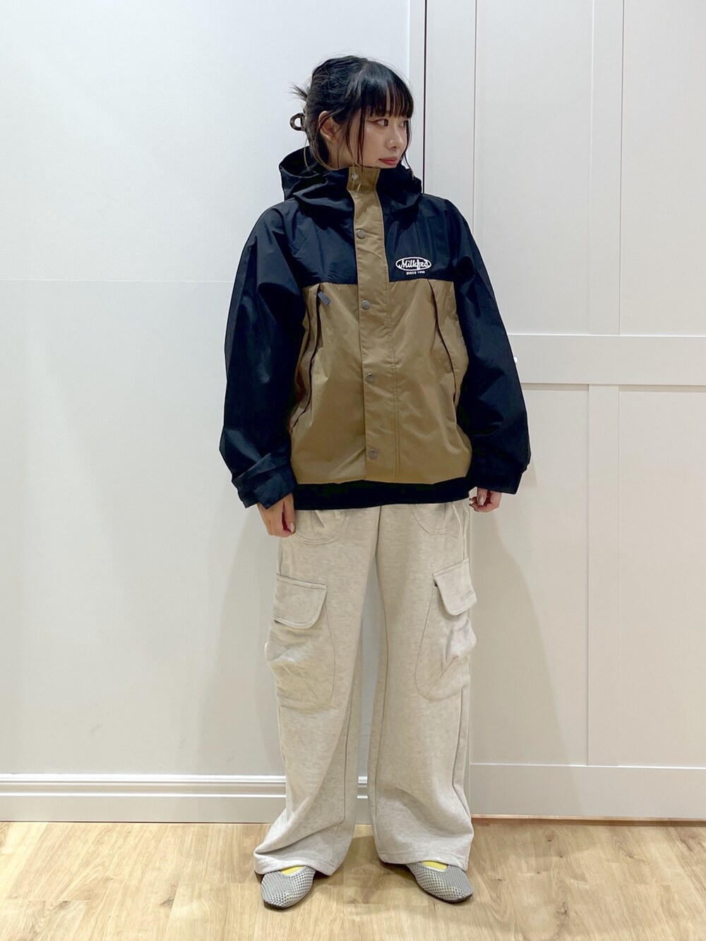 ベージュ系のスウェットパンツ、ベージュ系のマウンテンパーカー、ブラック系のTシャツ/カットソーを着用したレディースの秋コーディネートの2枚目の写真