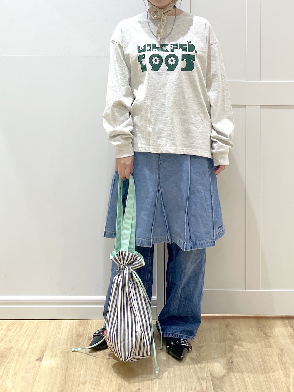 ホワイト系のダウンジャケット/コート、ベージュ系のTシャツ/カットソー、ブルー系のデニムパンツを着用したレディースの冬コーディネートの4枚目の写真