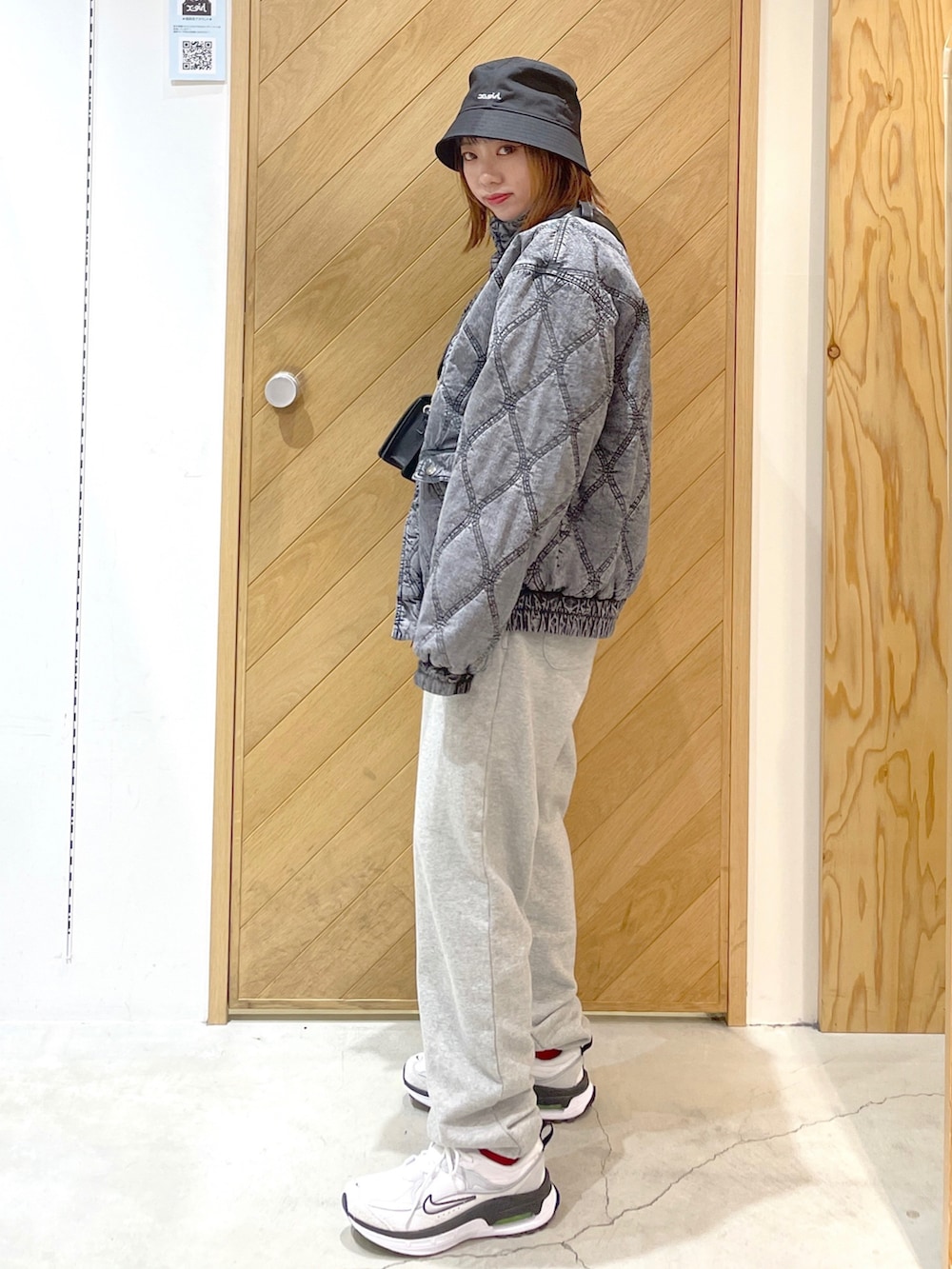 グレー系のスウェットパンツ、ホワイト系のスニーカー、ブラック系のその他アウターを着用したレディースの冬コーディネートの2枚目の写真