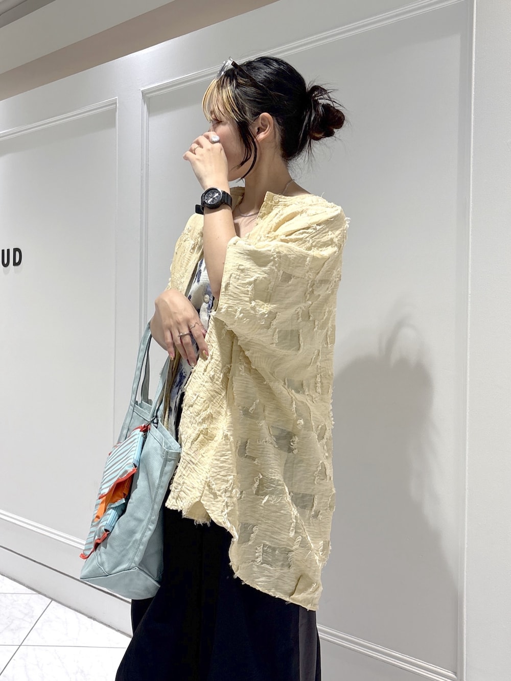 ブルー系のトートバッグ、ベージュ系のシャツ/ブラウス、ホワイト系のベストを着用したレディースの春コーディネートの5枚目の写真