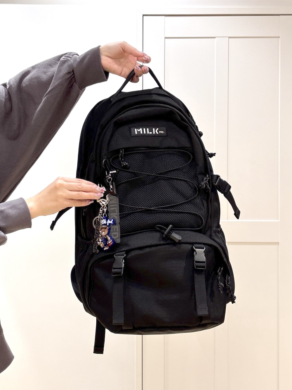 ホワイト系のデニムパンツ、グレー系のスウェット、ブラック系のバックパック/リュックを着用したレディースの冬コーディネートの6枚目の写真