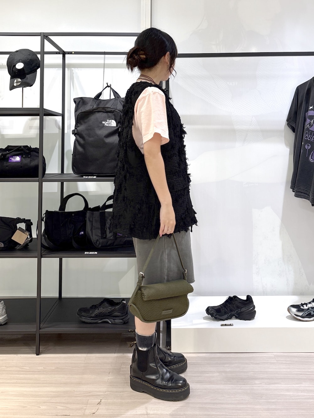 グリーン系のショルダーバッグ、ブラック系のブーツ、ピンク系のTシャツ/カットソーを着用したレディースの春コーディネートの2枚目の写真