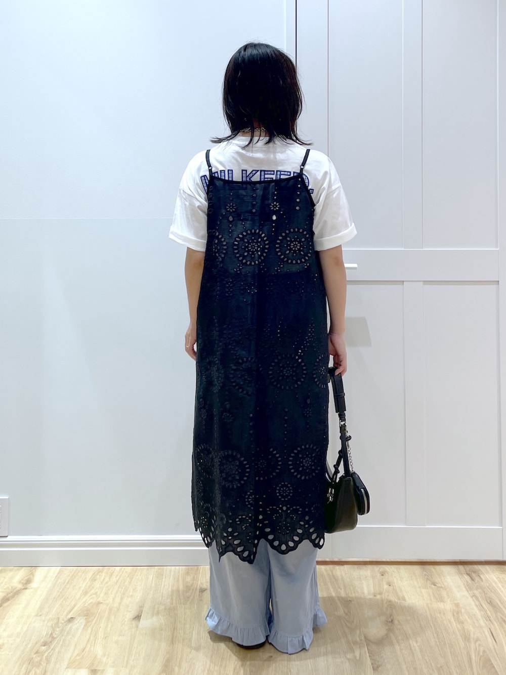 ブルー系のその他パンツ、ブラック系のブーツ、ブラック系のハンドバッグを着用したレディースの夏コーディネートの3枚目の写真