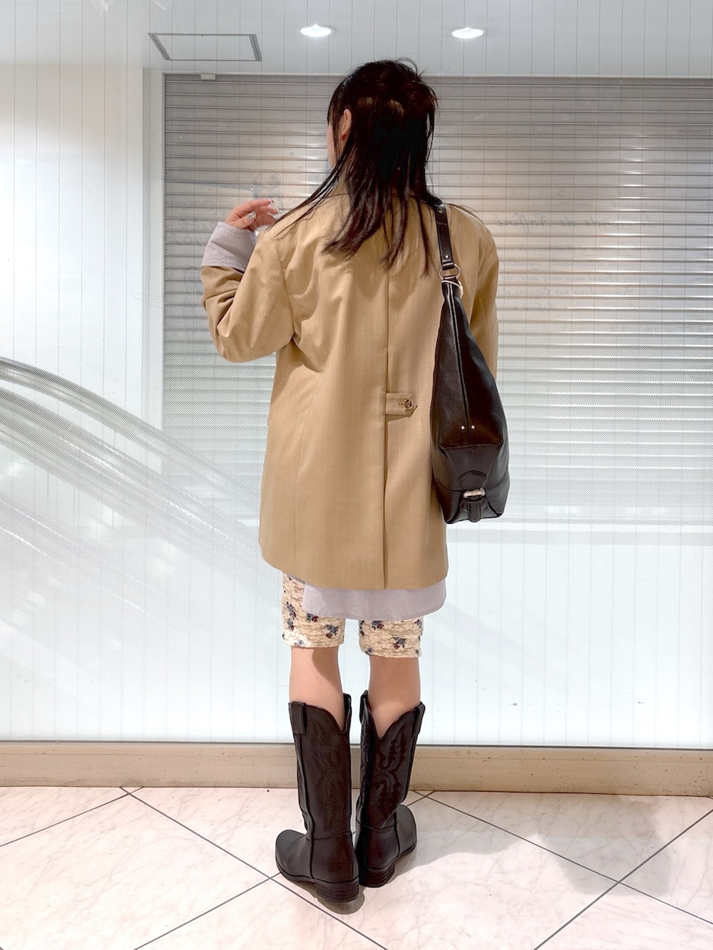 ブラック系のブーツ、ブルー系のシャツ/ブラウス、ベージュ系のテーラードジャケットを着用したレディースの春コーディネートの3枚目の写真