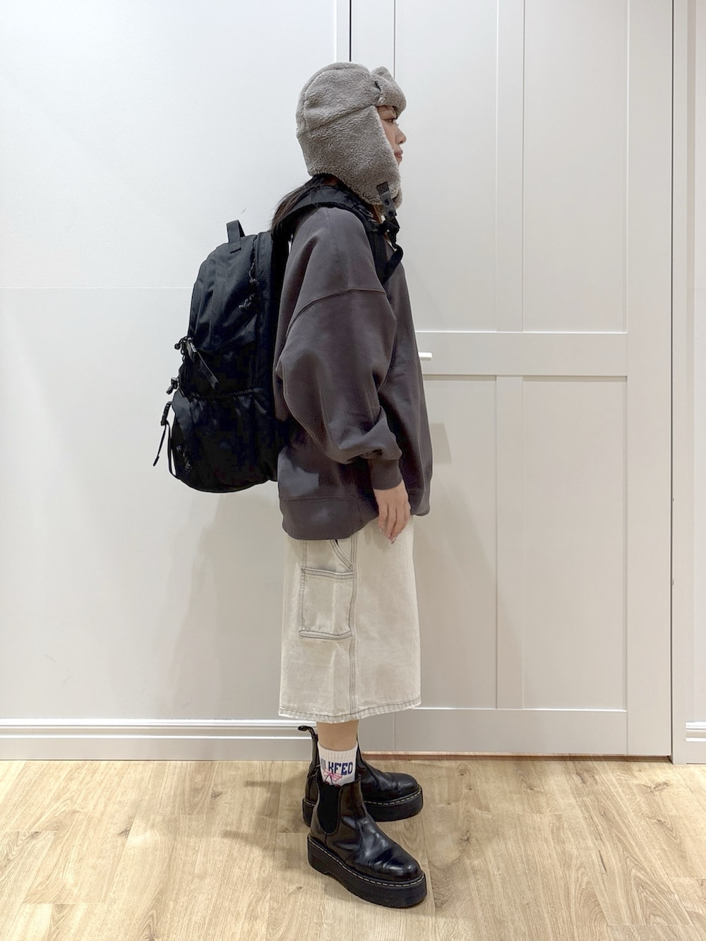 ホワイト系のデニムパンツ、グレー系のスウェット、ブラック系のバックパック/リュックを着用したレディースの冬コーディネートの3枚目の写真