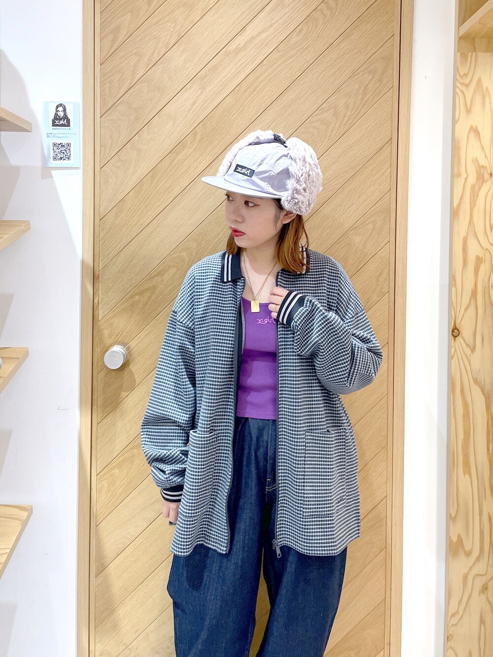 ブルー系のデニムパンツ、ホワイト系のスニーカー、パープル系のタンクトップを着用したレディースの秋コーディネートの2枚目の写真