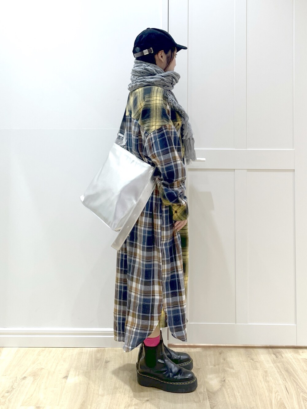 イエロー系のワンピース、ブラック系のブーツ、シルバー系のショルダーバッグを着用したレディースの秋コーディネートの3枚目の写真