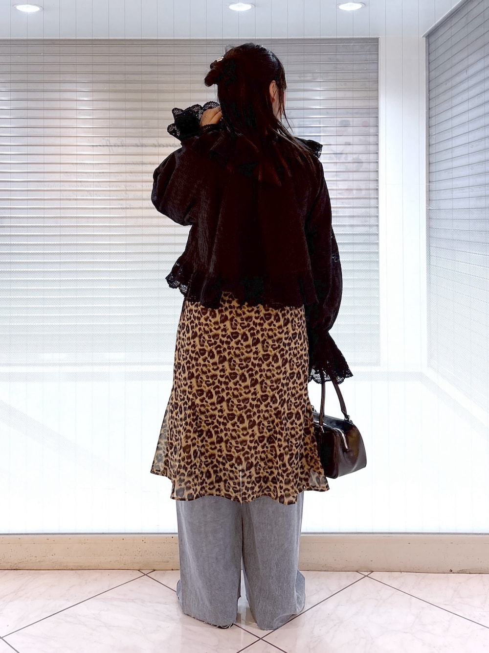 ブラック系のその他シューズ、ブルー系のデニムパンツ、ベージュ系のスカートを着用したレディースの春コーディネートの2枚目の写真