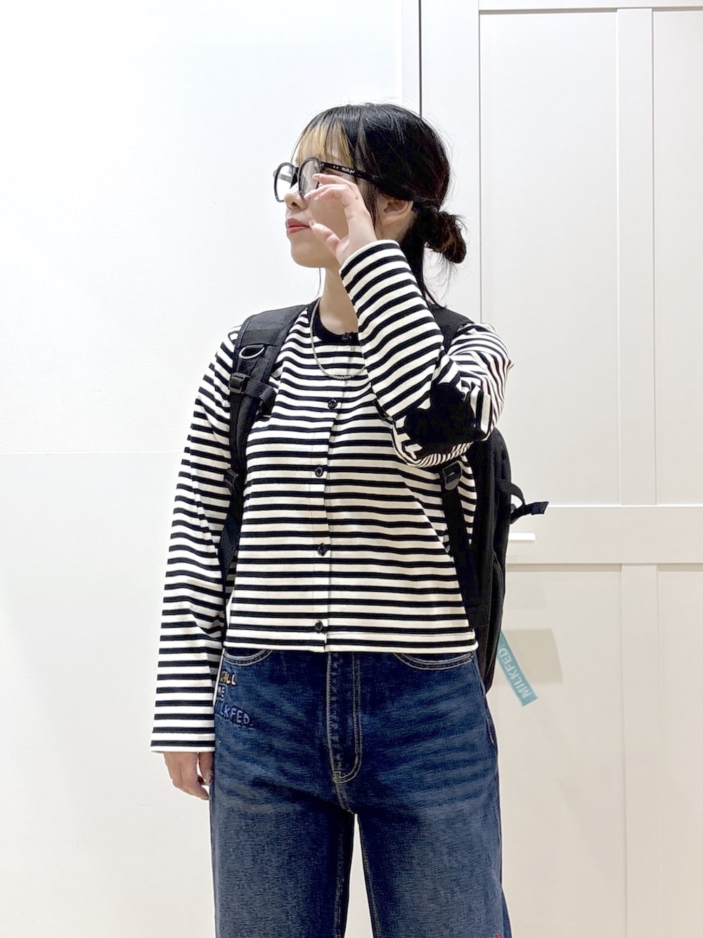 ブルー系のデニムパンツ、ブラック系のブーツ、ブラック系のカーディガン/ボレロを着用したレディースの春コーディネートの5枚目の写真