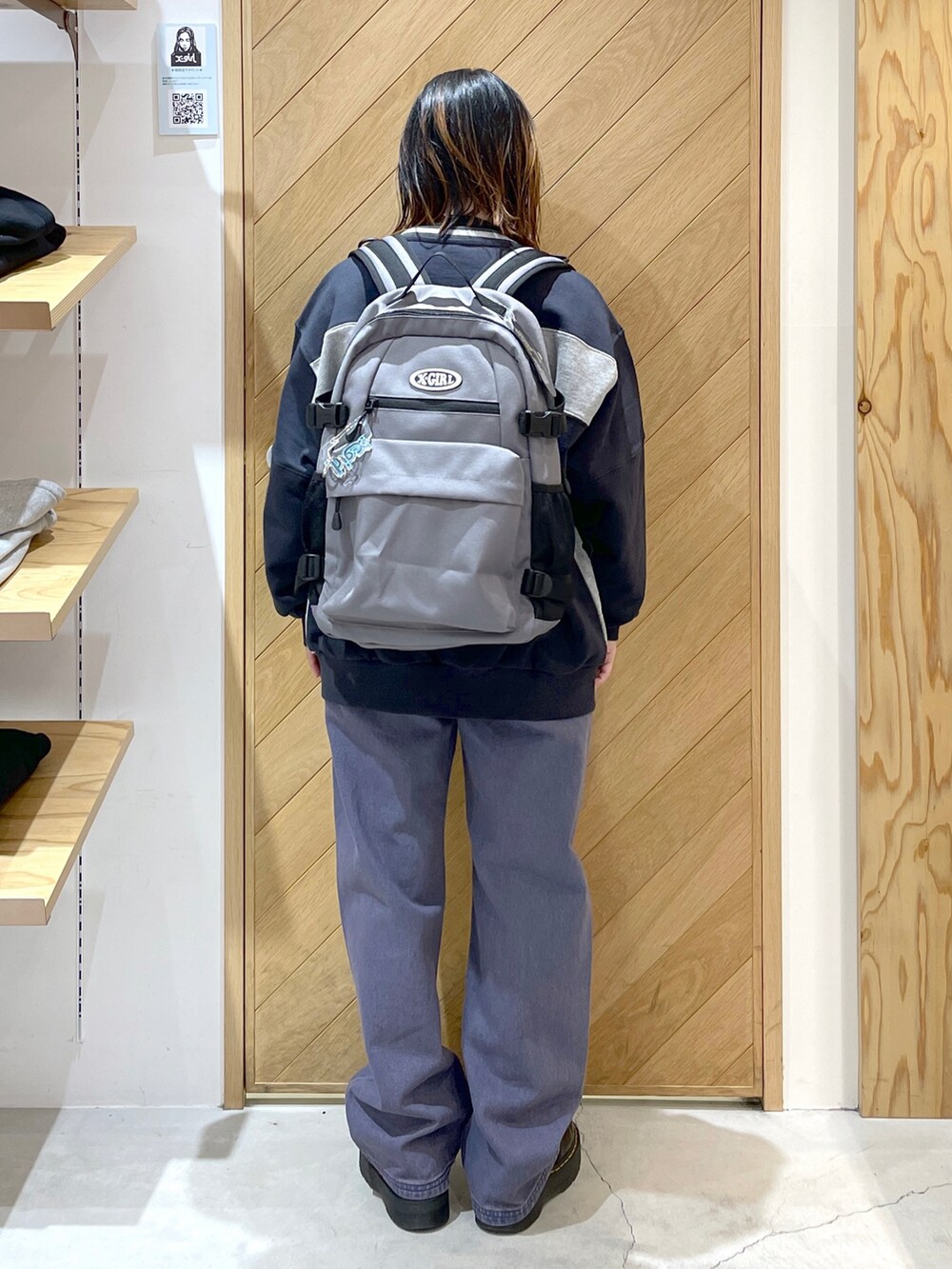 パープル系のデニムパンツ、ブラック系のブーツ、ホワイト系のTシャツ/カットソーを着用したレディースの冬コーディネートの3枚目の写真