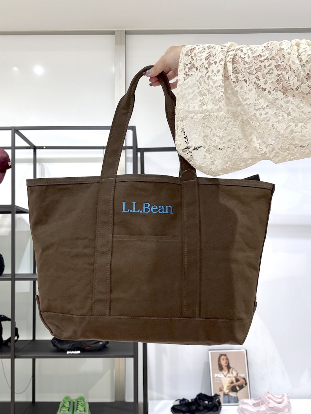 ブラウン系のトートバッグ、ブラウン系のサンダル、ホワイト系のTシャツ/カットソーを着用したレディースの春コーディネートの7枚目の写真