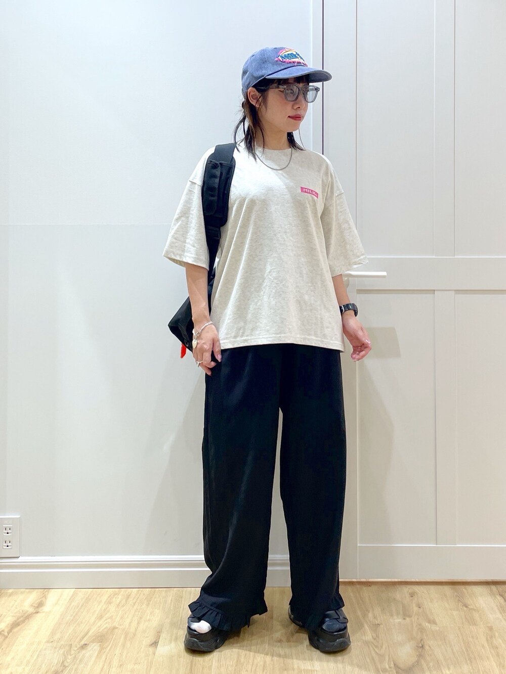 ブラック系のその他パンツ、ブラック系のサンダル、ブラック系のメッセンジャーバッグを着用したレディースの夏コーディネートの2枚目の写真