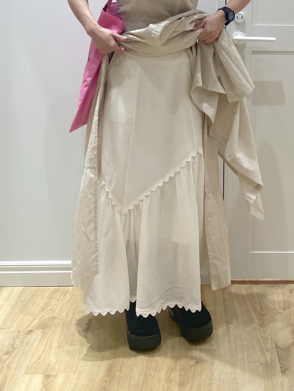 ホワイト系のワンピース、ホワイト系のスカート、ブラック系のサンダルを着用したレディースの春コーディネートの3枚目の写真