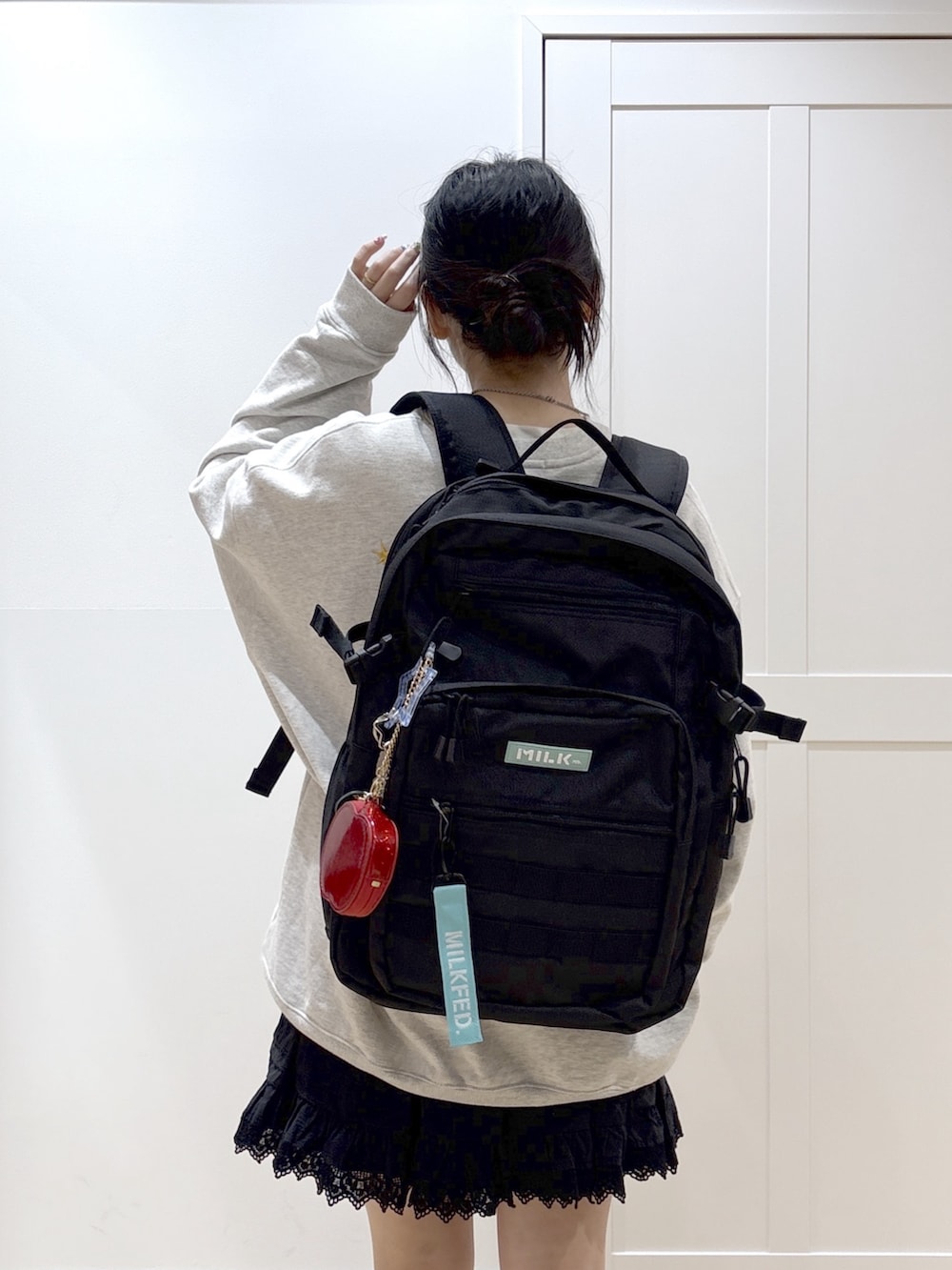 ブラック系のスカート、ベージュ系のスウェット、グリーン系のバックパック/リュックを着用したレディースの春コーディネートの5枚目の写真