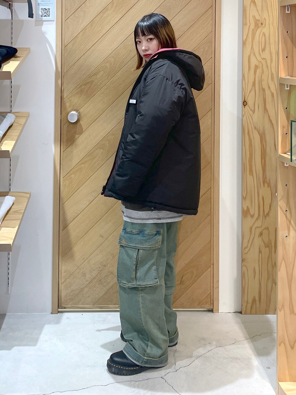 レッド系のナイロンジャケット、グレー系のTシャツ/カットソー、ブルー系のカーゴパンツを着用したレディースの冬コーディネートの3枚目の写真