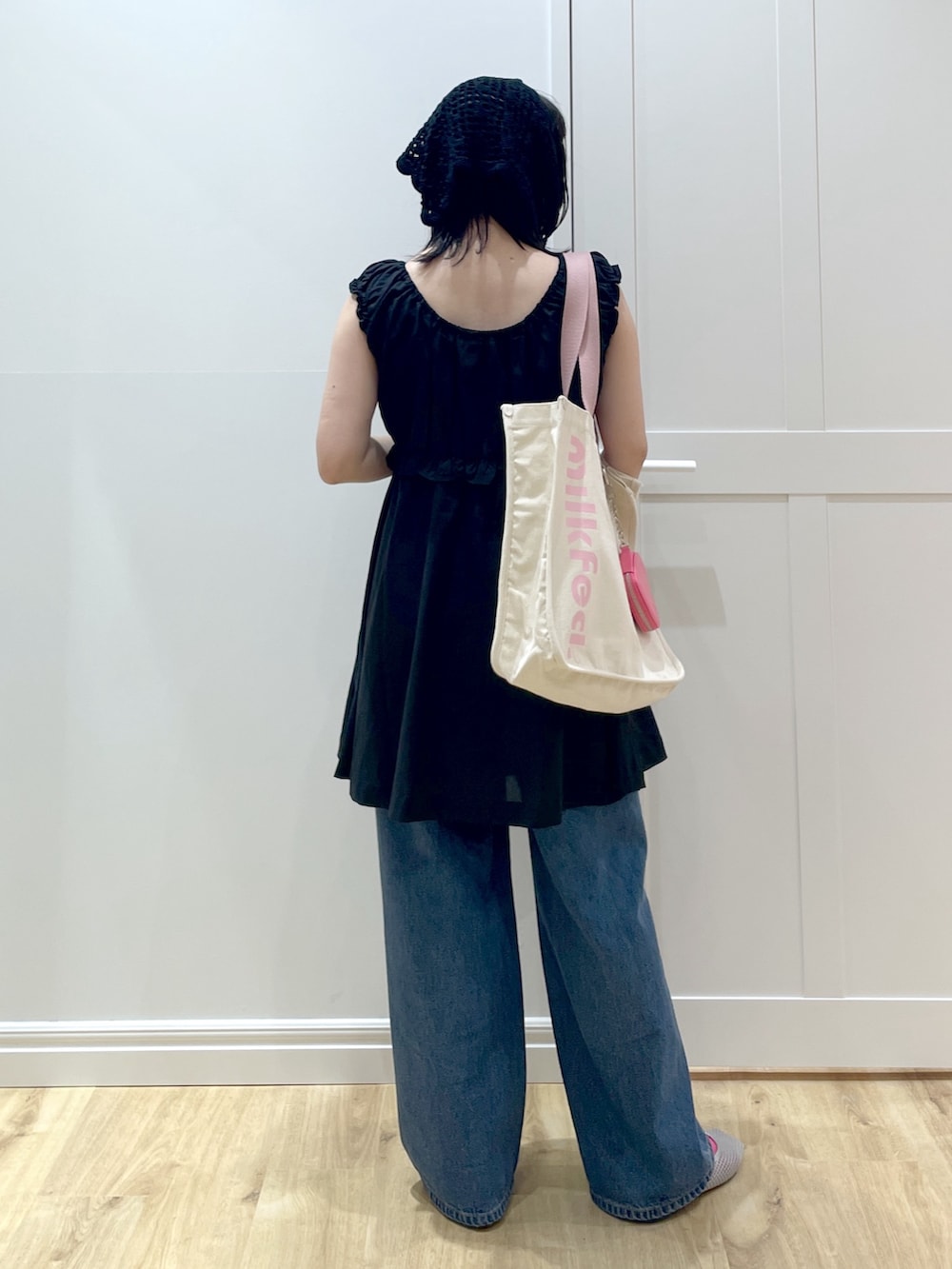 ホワイト系のトートバッグ、ブラック系のワンピース、ブルー系のデニムパンツを着用したレディースの夏コーディネートの3枚目の写真