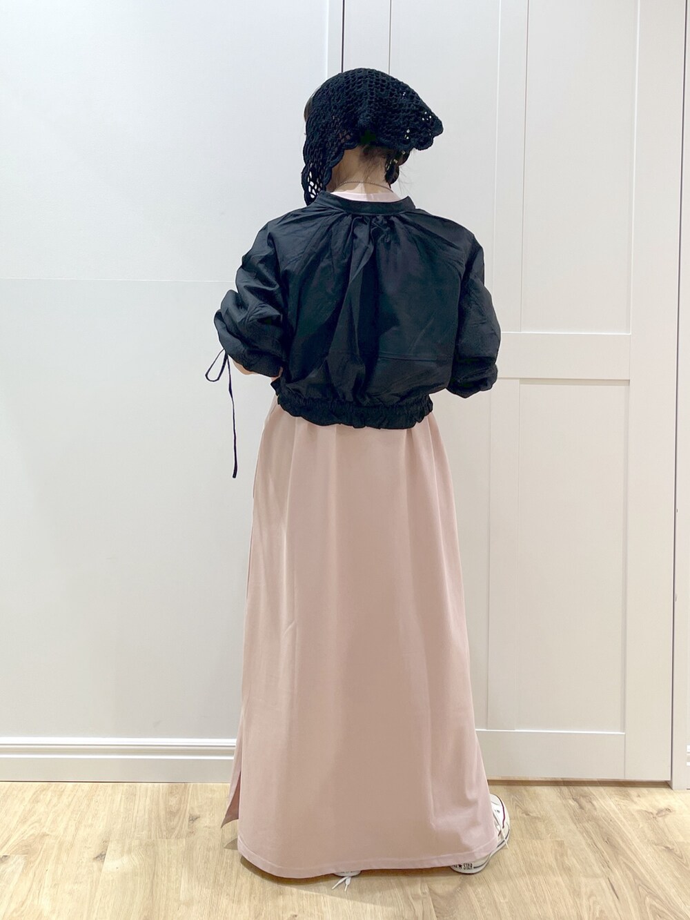 ピンク系のワンピース、ホワイト系のスニーカー、ブラック系のカーディガン/ボレロを着用したレディースの春コーディネートの2枚目の写真