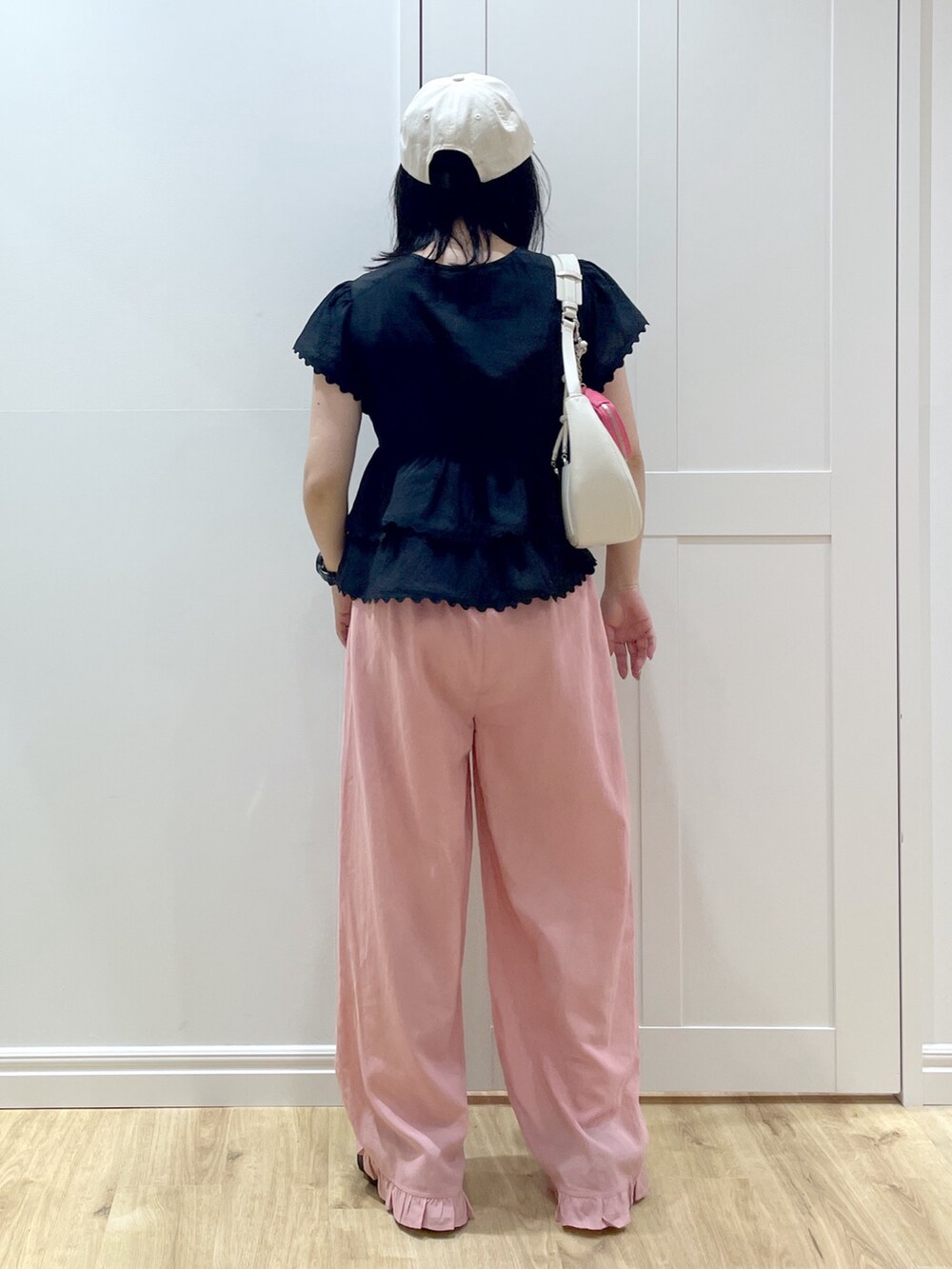 ホワイト系のハンドバッグ、ブラック系のサンダル、ブラック系のシャツ/ブラウスを着用したレディースの夏コーディネートの3枚目の写真