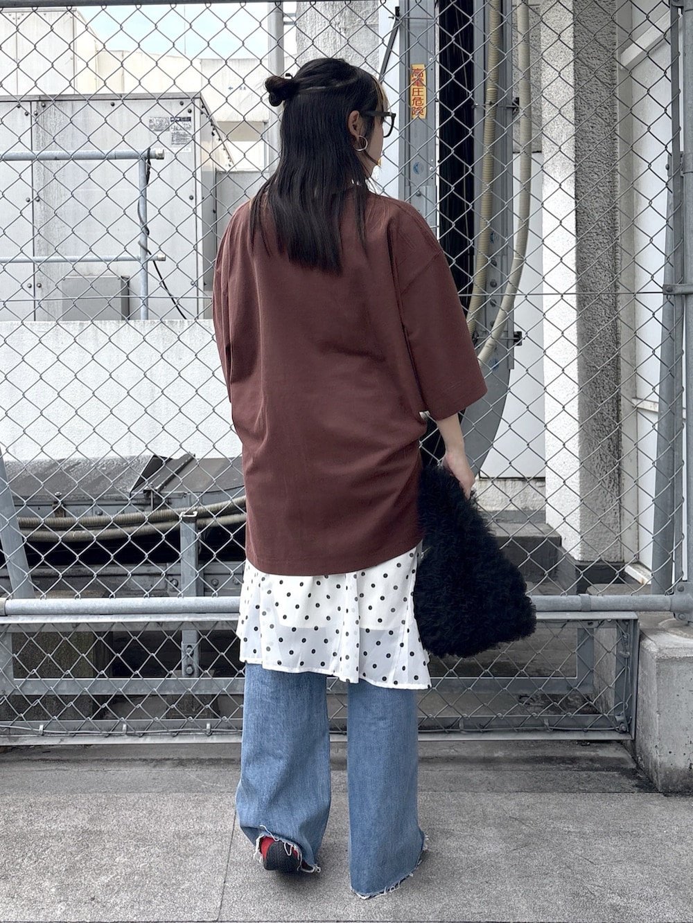 ブルー系のデニムパンツ、レッド系のスニーカー、ホワイト系のスカートを着用したレディースの春コーディネートの3枚目の写真