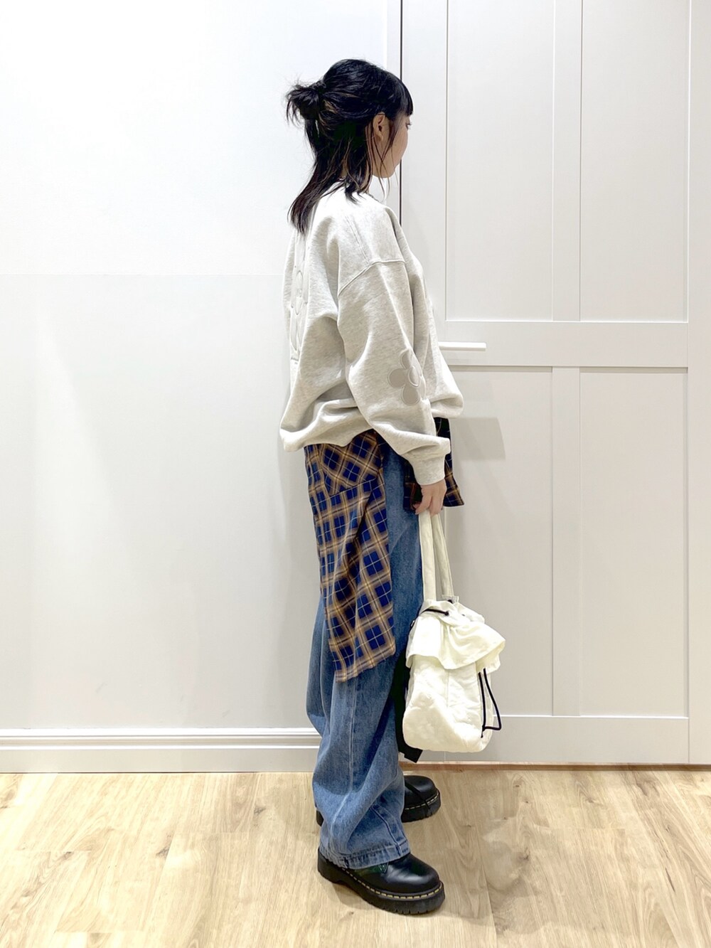 ベージュ系のスウェット、ブルー系のシャツ/ブラウス、ブルー系のデニムパンツを着用したレディースの秋コーディネートの2枚目の写真