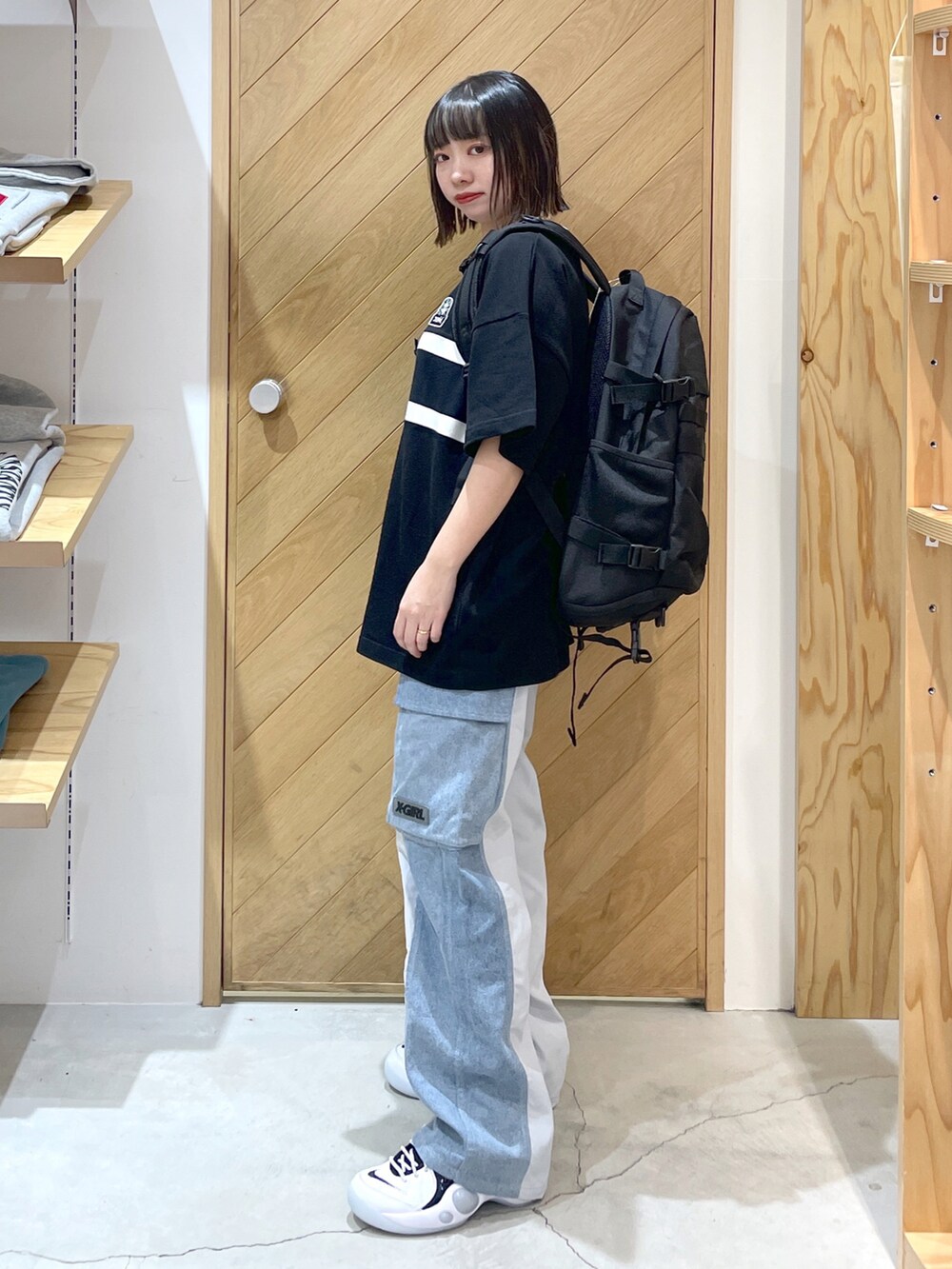 グレー系のデニムパンツ、ブラック系のスニーカー、ブラック系のバックパック/リュックを着用したレディースの春コーディネートの2枚目の写真