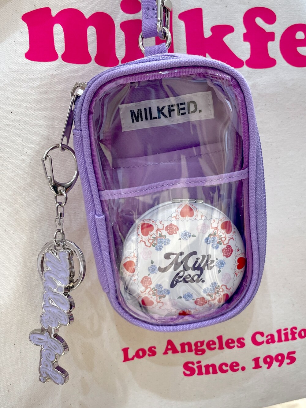 パープル系のタンクトップ、ホワイト系のTシャツ/カットソー、ブルー系のデニムパンツを着用したレディースの夏コーディネートの5枚目の写真