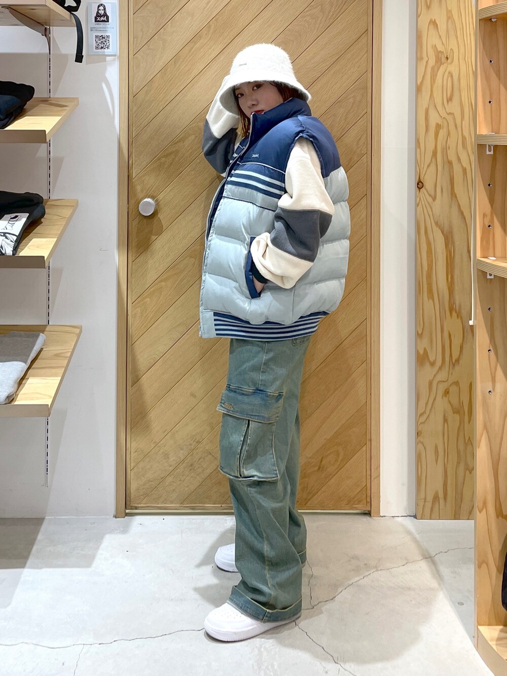 ブルー系のベスト、ブルー系のカーゴパンツ、ホワイト系のスニーカーを着用したレディースの秋コーディネートの2枚目の写真