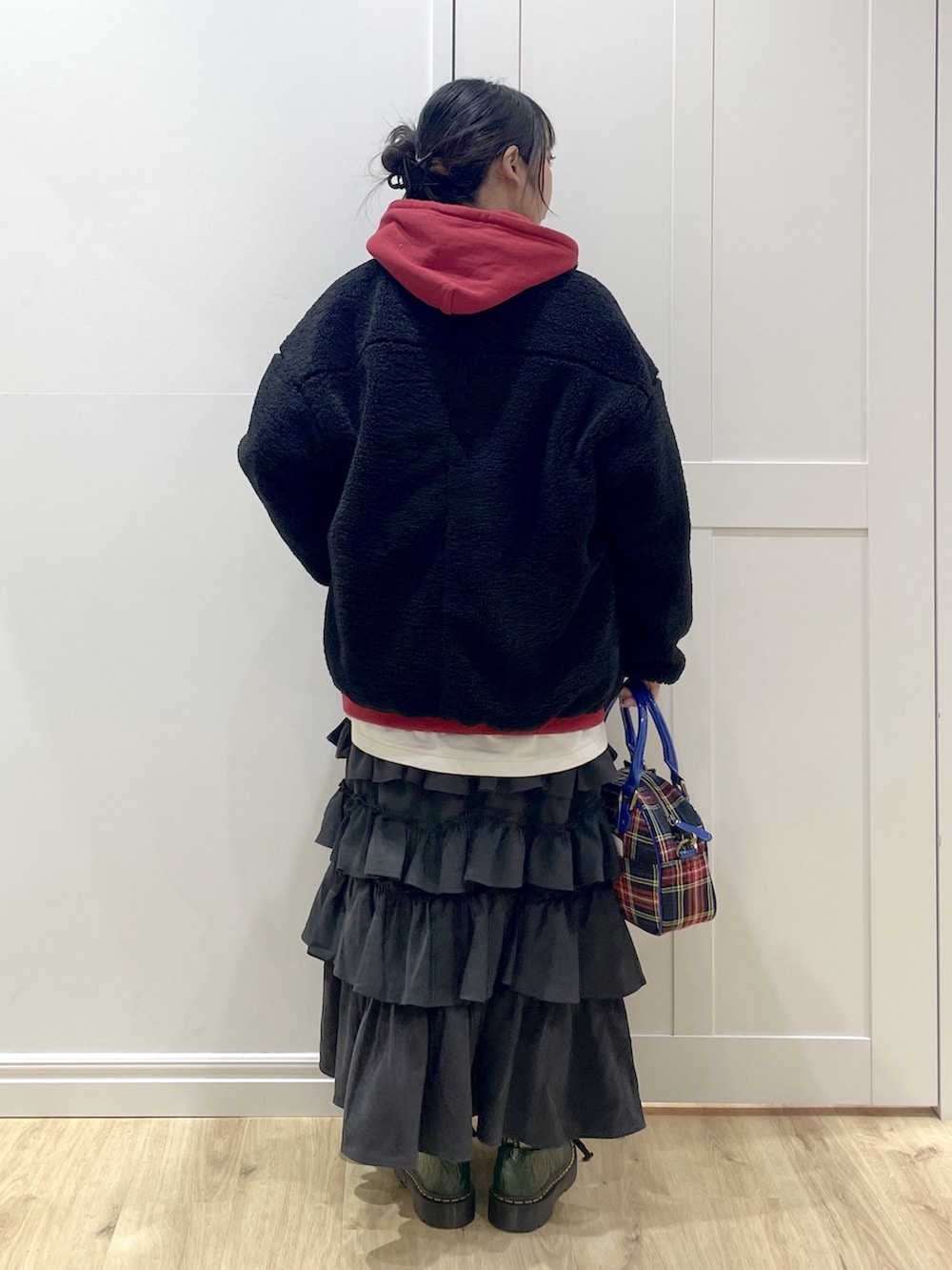 ブラック系のブーツ、ブラック系のショルダーバッグ、ブラック系のスカートを着用したレディースの冬コーディネートの4枚目の写真