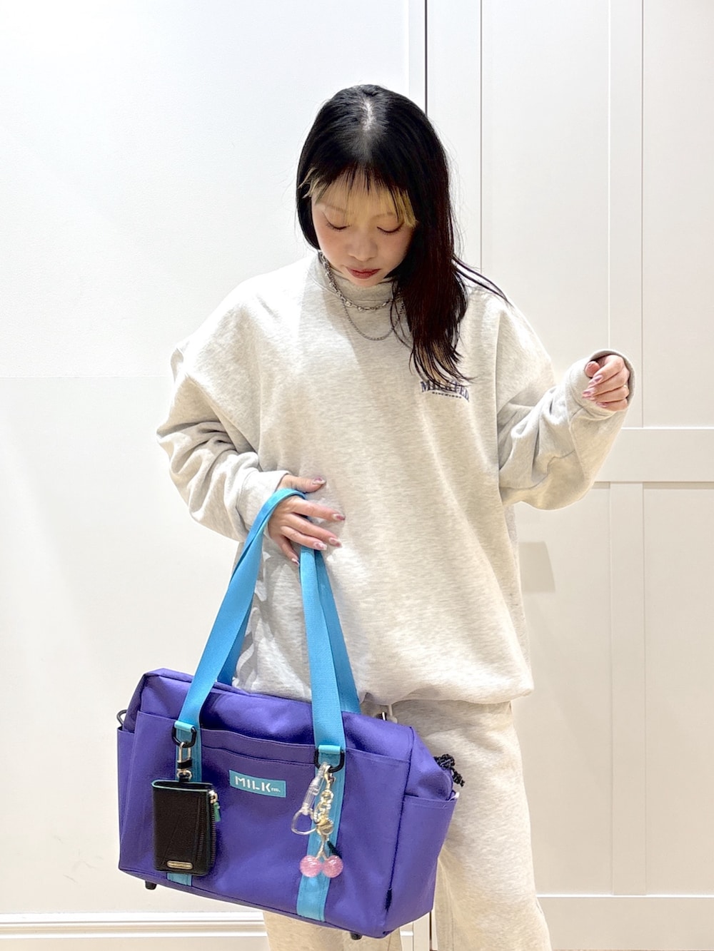 ベージュ系のスウェット、ベージュ系のスウェットパンツ、パープル系のショルダーバッグを着用したレディースの冬コーディネートの7枚目の写真