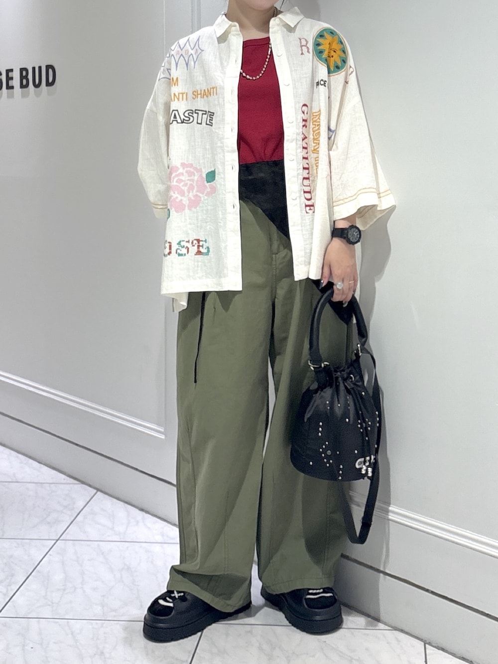 グリーン系のデニムパンツ、レッド系のタンクトップ、ブラック系のサンダルを着用したレディースの夏コーディネートの4枚目の写真